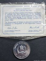 Medallion with certificate card detailing Silver Jubilee information