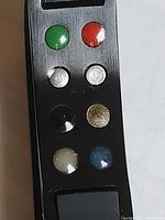 Close-up of metal plate with seven coloured discs on bracelet