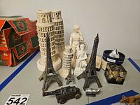 Group shot showing entire assortment of Eiffel Towers, Pisa towers, statues, cannon, rocket, coin cube and pyramid