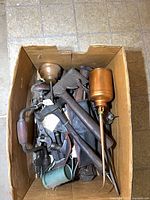Top view of box showing mix of hand tools including oilers, brace drill, pipe wrench, files