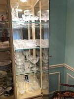 Cabinet view showing multiple shelves of cut crystal glassware