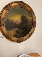 Full view of circular framed landscape painting