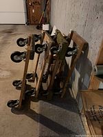 Stack of four wood frame dollies showing casters and pads