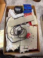 Boxed lot showing mixed track sections, wiring, support parts and instruction sheet