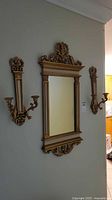 Full view of mirror and both sconces mounted on wall
