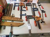 Overview of assorted bar, pipe and handscrew clamps on table