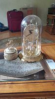 Clock under glass dome on table