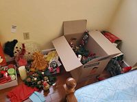 Overview of box with assorted Christmas decorations on floor