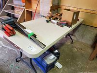 Full view of rectangular plastic folding table with tools on top