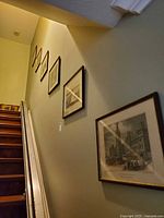 Five framed prints on stairway wall
