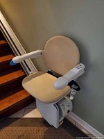 Stair lift chair side view against wall and rail