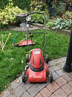 Front and side view of Homelite lawn mower on patio and grass