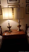 Both brass table lamps with shades on nightstand