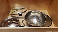 Drawer showing colander, lids, splatter screen
