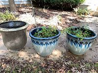All three outdoor planters: dark grey composite, two matching blue/beige ceramic