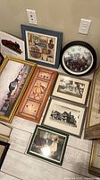 Group of framed prints and clock arranged on floor showing variety and condition