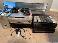 Front view of all stacked components with subwoofer, CD changer, receiver, remotes, cables