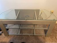 Front view showing glass top, shelves, frame, cable hole