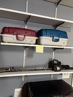 Two tackle boxes on shelf, rods stored below