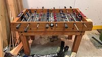 Full view of wooden foosball table with rods and players