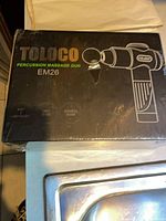 Front of sealed Toloco EM26 percussion massage gun box