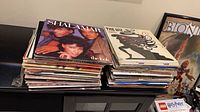 Two tall stacks of LPs on cabinet, top records Shalamar The Look and The Wiz soundtrack visible
