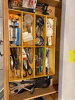Full drawer view displaying organizer and variety of utensils