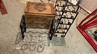 Overall lot showing two metal racks, wooden crate, three glasses