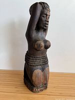 Front view of carved wooden female figure showing overall design and condition