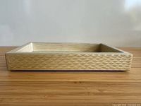 Side view of ivory resin tray showing wave relief pattern