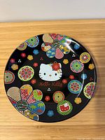 Front of black Hello Kitty plate with colourful design
