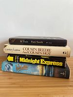 Stack of four hardcover books showing spines