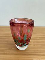 Full view of multicoloured hand blown glass vase on wooden surface