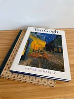 Cover shot of Van Gogh book stacked over Louvre book