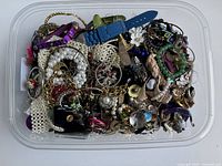 Top view of tub filled with assorted costume jewelry pieces