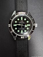 Close front view of watch face showing dial, bezel, crown, strap texture