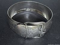Full view of sterling silver buckle bangle showing engraved floral pattern and overall form