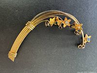 Full view of curved sterling brooch with floral rhinestone charms