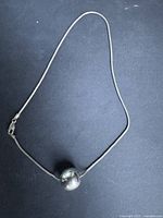 Full view of sterling silver snake chain necklace with spherical bead