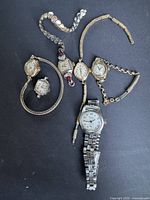 Group shot of eight vintage wristwatches on black background