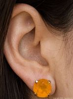 Earring worn in ear showing size and color of carnelian stone