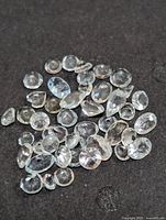 Group of loose faceted aquamarine stones on dark background