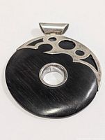 front view of round pendant showing silver overlay and center hole