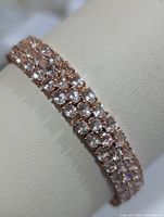 Full view of bracelet on display showing three rows of morganite stones