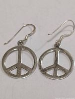 Front view of both peace sign earrings showing design and hooks