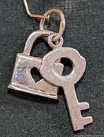 Front view of silver padlock and key pendant