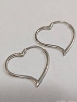 front view of both heart-shaped silver earrings