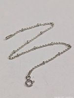 Full view of silver chain bracelet laid flat showing bead accents and clasp