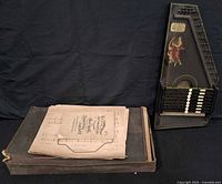 autoharp, sheet music stack and case overview