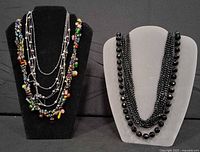 Full view of two necklace stands showing all necklaces